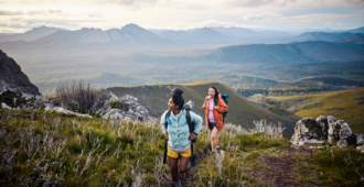 Women immersing themselves in the untouched wilderness of Tasmania through adventurous bushwalking.