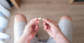 A man's hands breaking a cigarette from the point of view of the man