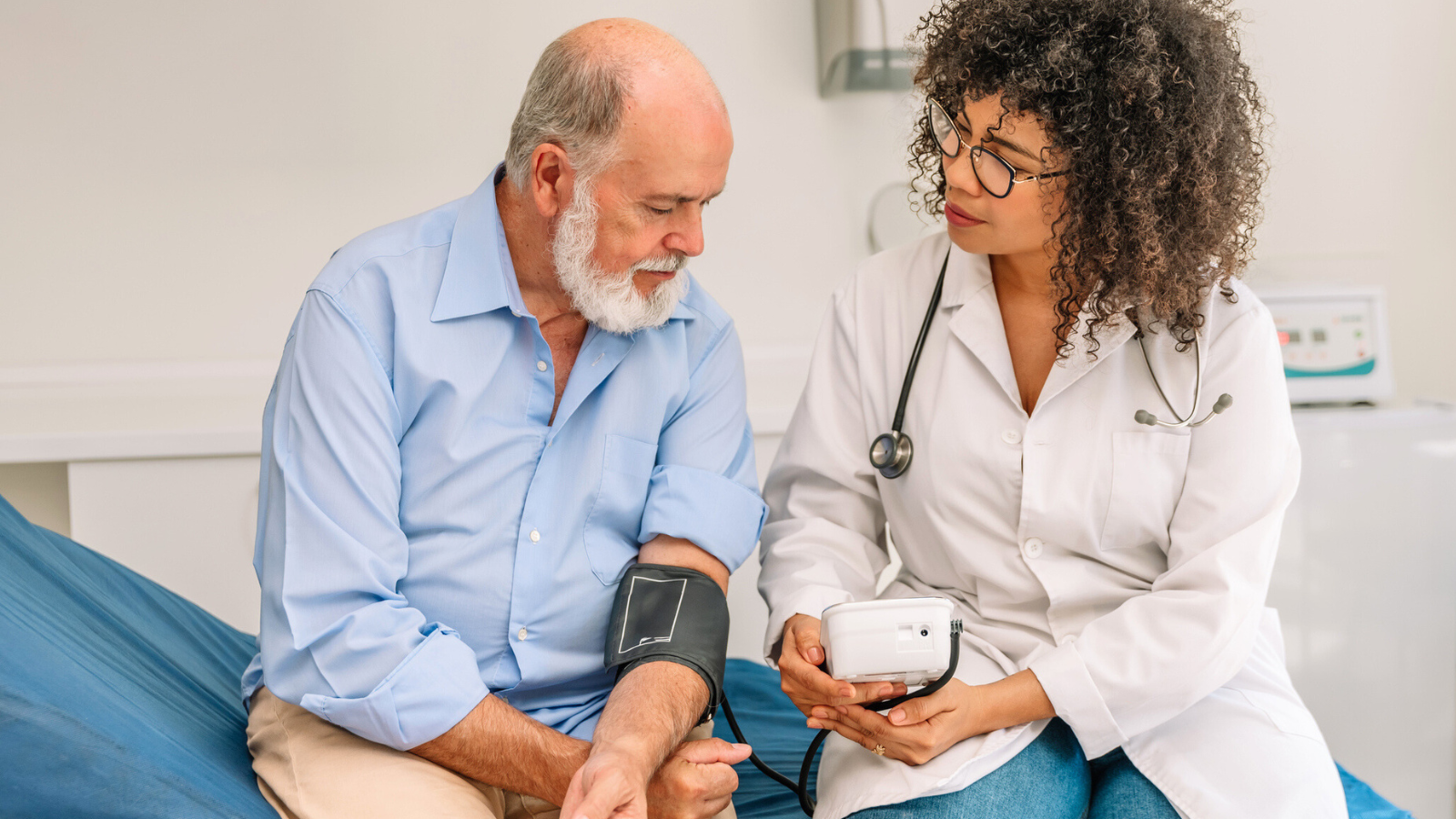 Latin female physician measuring a patient's blood pressure on a gurney stock photo