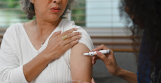 stock image of a senior woman taking an insulin injection from a nurse