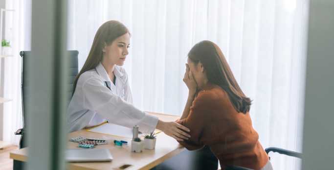 GP comforting patient during a consultation