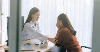 doctor comforting a female patient stock image