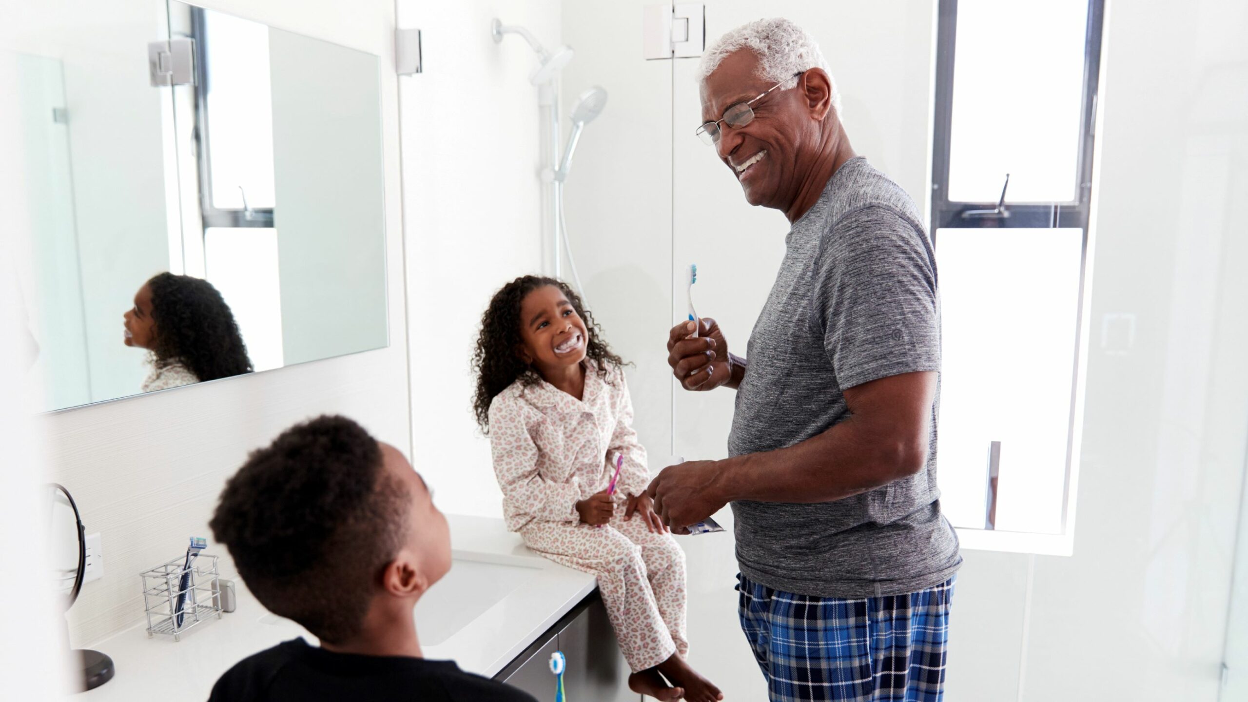 grandfather brushing teeth with young kids