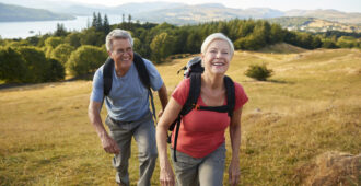 Senior Couple Climbing Hill On Hike