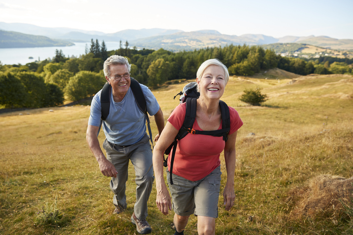 Senior Couple Climbing Hill On Hike