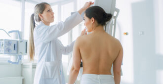 stock image of woman adjusting her position to do a mammogram