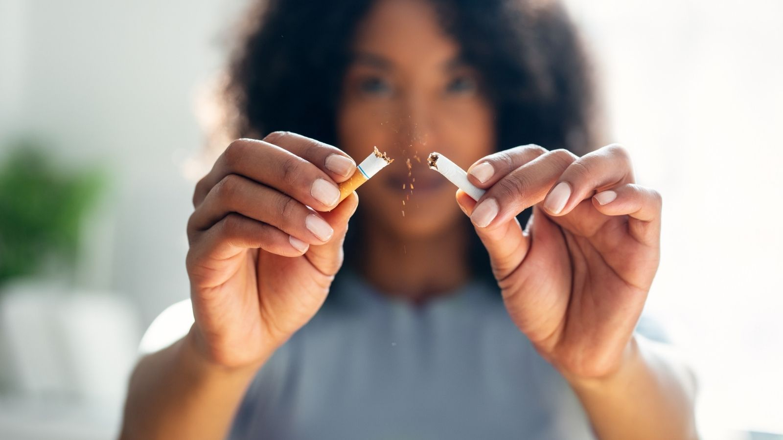 Woman breaking down cigarette to pieces